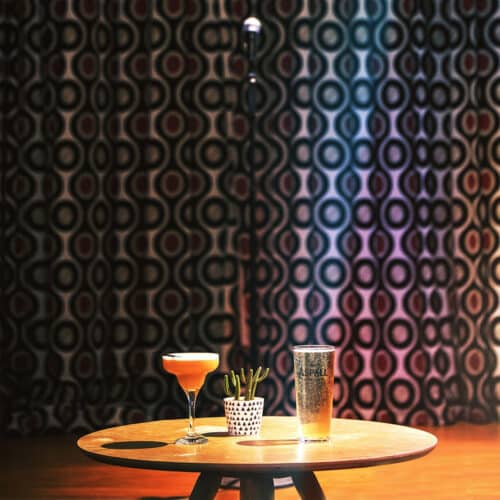 Table with two drinks on it with a small plant