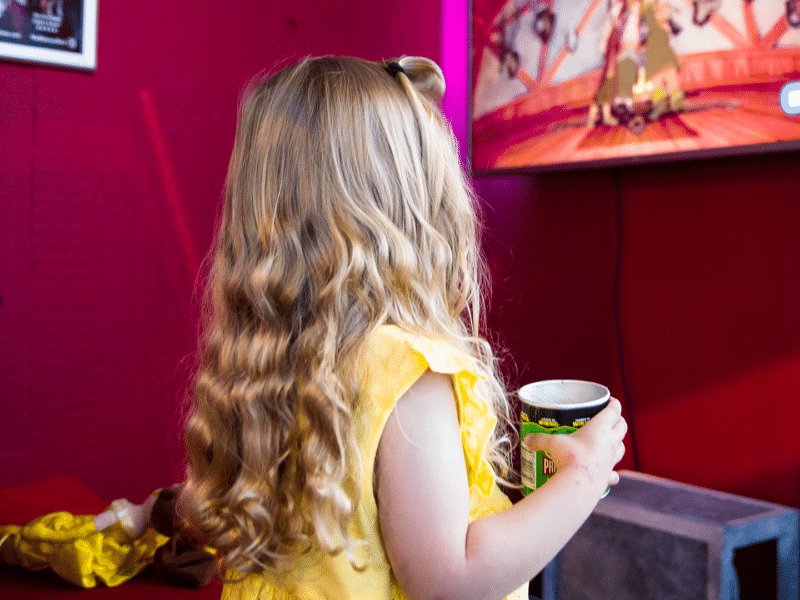 Child sat in cinema at Harlow Playhouse watching something on the TV screen