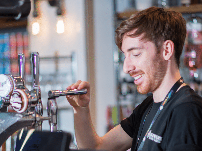 Person pulling pint smiling